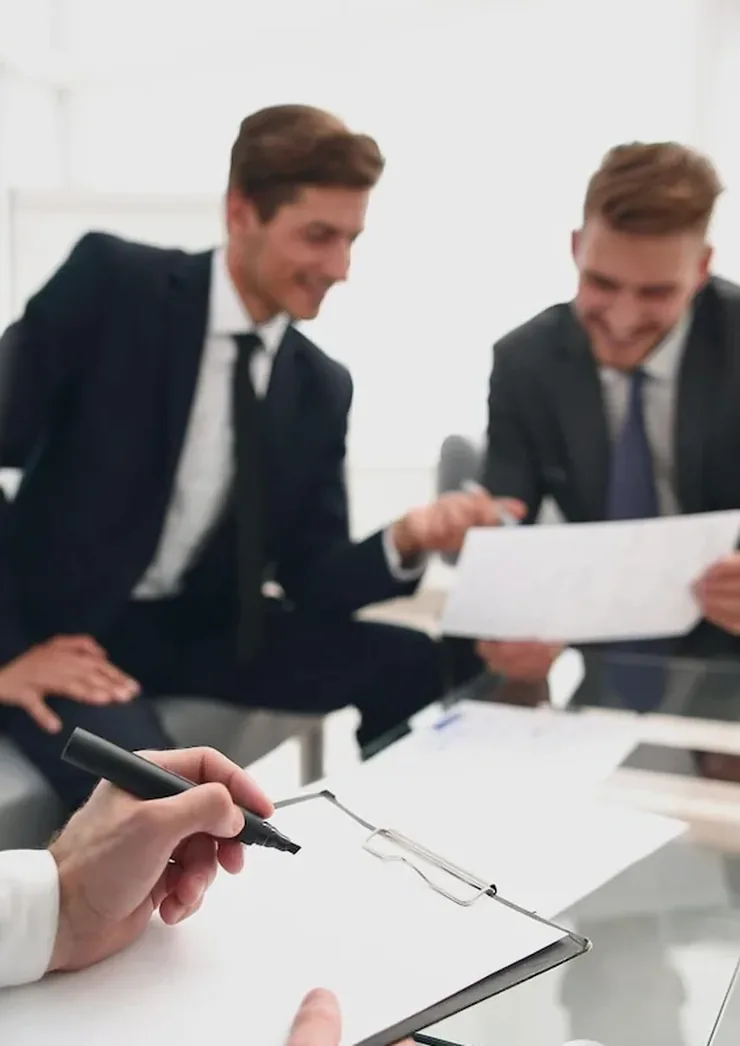 Two men going over documents at a white table