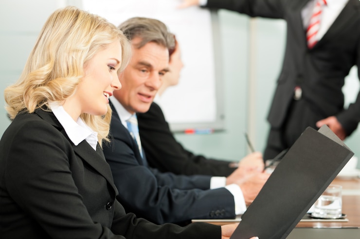 A man and a woman looking over a folder together in an office